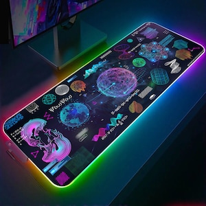 May include: A black and blue gaming mouse mat with a colourful, geometric design. The design features a variety of shapes, including circles, squares, and triangles. The mouse mat is illuminated with a rainbow-coloured LED light.