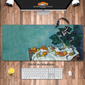 May include: A rectangular desk mat featuring a still life painting of oranges and a potted plant on a white cloth against a teal background. The mat measures 90 by 40 cm and displays a textured, painterly aesthetic with visible brushstrokes.