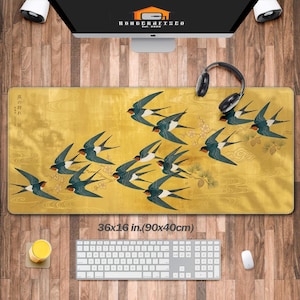 Puede incluir: Alfombrilla de ratón rectangular con fondo amarillo dorado que representa una bandada de golondrinas en vuelo. La alfombrilla mide 90 x 40 cm e incluye teclado y ratón.