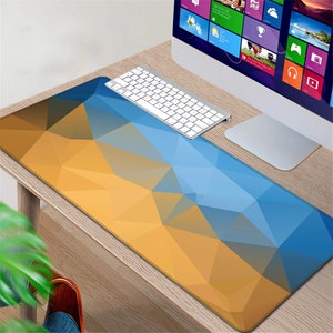 May include: A blue and yellow geometric patterned mouse pad on a wooden desk with a keyboard and a computer monitor.