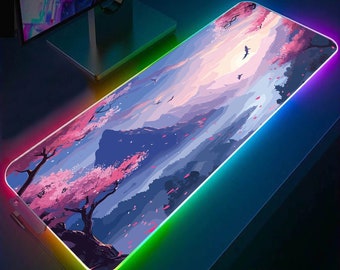 May include: A large rectangular mousepad with a colorful, glowing border. The mousepad features a digital illustration of a mountain landscape with pink cherry blossoms and a sunset sky.