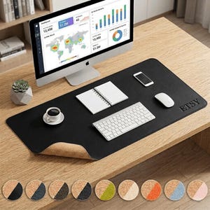 May include: A black desk mat with a cork underside, a computer, keyboard, mouse, notepad, and a coffee cup. The mat has the word "ETSY" embossed on the right side. A variety of cork coasters are displayed below the mat.