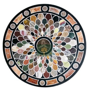 May include: A round, black marble table top with a colorful, floral design. The design features a variety of different colored marbles arranged in a circular pattern.