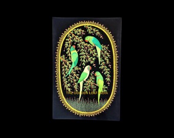Puede incluir: Una pintura sobre lienzo negro con un marco ovalado dorado. Dentro del marco, cuatro periquitos verdes y amarillos están posados en las ramas de un árbol. El texto "THE GOLDEN LEAF INDIA" está en la parte inferior de la pintura.