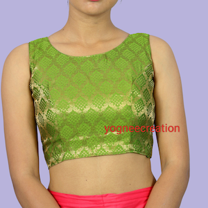 Puede incluir: Una blusa verde sin mangas con un patrón de brocado y un escote redondo. La blusa es corta y tiene un estilo ajustado.
