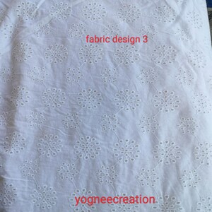 Puede incluir: Tela blanca con un dise&ntilde;o floral calado. La tela tiene un patr&oacute;n repetido de flores bordadas. El texto "fabric design 3" es visible en rojo. El texto "yogneecreation" tambi&eacute;n es visible.