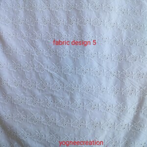 Puede incluir: Tela blanca con un patr&oacute;n floral bordado. La tela tiene una apariencia delicada y texturizada. Las palabras "fabric design 5" y "yogneecre&aacute;tion" est&aacute;n impresas en la tela.