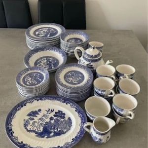 May include: A set of blue and white china dinnerware featuring a willow pattern. The set includes plates, bowls, cups, saucers, and a teapot.
