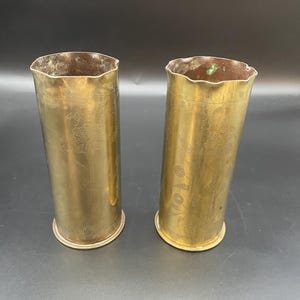 May include: Two brass vases, each with an engraved floral design. One vase has the number "19" engraved on it.