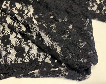 Puede incluir: Tela de encaje negra con un delicado patrón floral. El encaje es suave y transparente, y sería perfecto para una variedad de proyectos, como ropa, accesorios y decoración del hogar.
