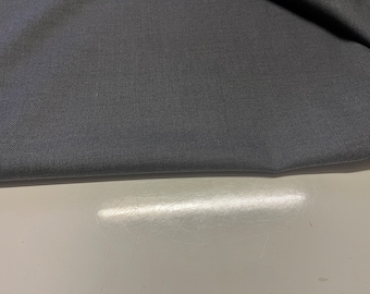 May include: A close-up of a dark gray fabric with a subtle texture. The fabric is folded in half and the edge is visible.