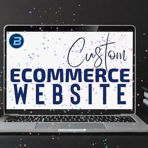 May include: A laptop computer with a white screen displaying the text "Custom ECOMMERCE WEBSITE" in blue text. The screen also has a blue circle with a white letter "B" in the upper left corner. The laptop is on a black surface with a stack of books to the right.