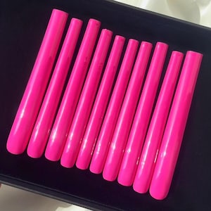 May include: A set of ten bright pink fake nails in various sizes, arranged in a black box.