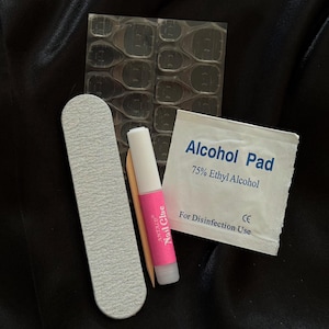May include: A set of nail art supplies including a nail file, a small bottle of nail glue, a pack of adhesive tabs, and an alcohol pad labeled "Alcohol Pad 75% Ethyl Alcohol For Disinfection Use CE"