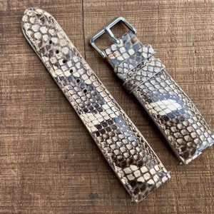 May include: Two brown and white patterned leather watch straps with silver buckles.