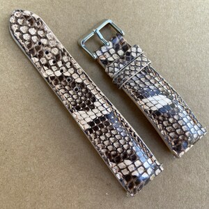 Peut inclure: Deux bracelets de montre en peau de serpent marron et blanc avec des boucles argentées.