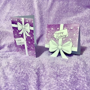 Tarjeta de cumpleaños con forma de regalo y lunares morados