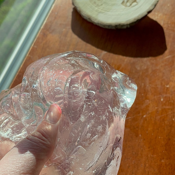 May include: A clear, translucent slime with a textured surface. The slime is being held in a hand.