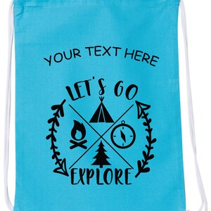 May include: A turquoise blue drawstring bag with the text "YOUR TEXT HERE" at the top and a black graphic of a compass, campfire, tent, and pine tree with the text "LET'S GO EXPLORE" in a circle.