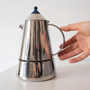 Puede incluir: Un juego de tres tazas de cerámica con un acabado mate moteado. Las tazas son en tonos crema, gris claro y gris oscuro. Cada taza tiene un diseño simple y minimalista y un asa redondeada.