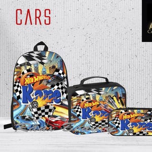 May include: A set of three black bags with a Hot Wheels theme. The backpack features a checkered flag design with the words "Hot Wheels" and "Kane" printed on it. The lunch bag and pencil case have a similar design.