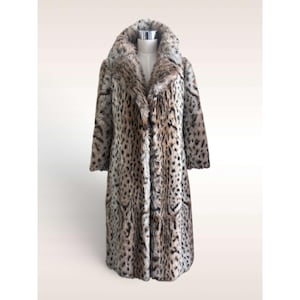 May include: A long, full-length coat featuring a realistic leopard print pattern in shades of tan, brown, and black. The garment has a wide, plush collar and long sleeves, displaying a textured, fur-like appearance throughout the entire exterior.
