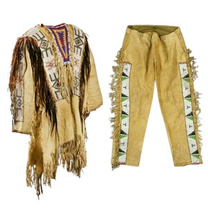 以下が含まれることがあります： フリンジとビーズで飾られた革製の伝統的なネイティブアメリカンの衣装。衣装には長袖のシャツとズボンが含まれています。