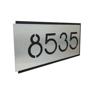 May include: A silver metal house number sign with black numbers. The number is 8535.