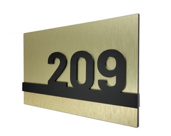 May include: A gold metal sign with black numbers reading "209".