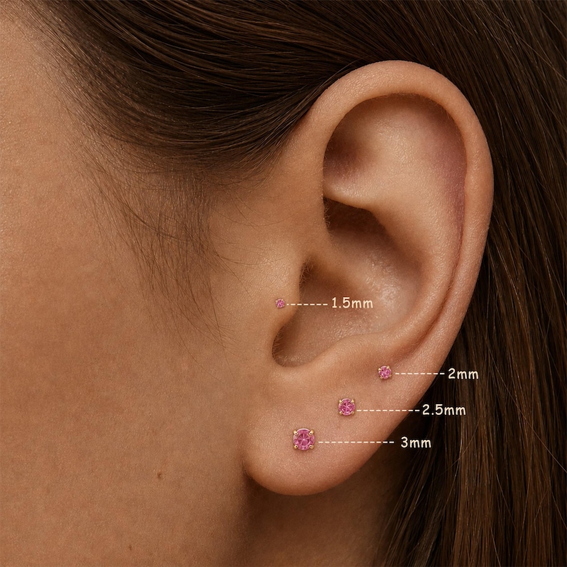 K&ouml;nnte beinhalten: Nahaufnahme eines Ohrs mit vier rosa Edelstein-Ohrsteckern. Die Ohrringe sind 1,5 mm, 2 mm, 2,5 mm und 3 mm gro&szlig;. Die Ohrringe sind in Gold gefasst. Das Bild zeigt die Ohrringe im Ohr.