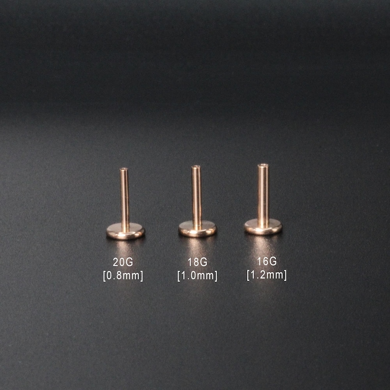 Puede incluir: Tres tachuelas de piercing corporal de color dorado de diferentes tama&ntilde;os. Las tachuelas est&aacute;n etiquetadas como 20G [0,8 mm], 18G [1,0 mm] y 16G [1,2 mm].