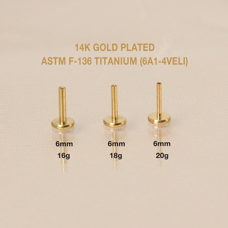 May include: Three gold-plated titanium body jewelry pieces, each with a 6mm diameter and different gauge sizes: 16g, 18g, and 20g. The jewelry is labeled with the gauge size and the text "14K GOLD PLATED ASTM F-136 TITANIUM (6A1-4VELI)".