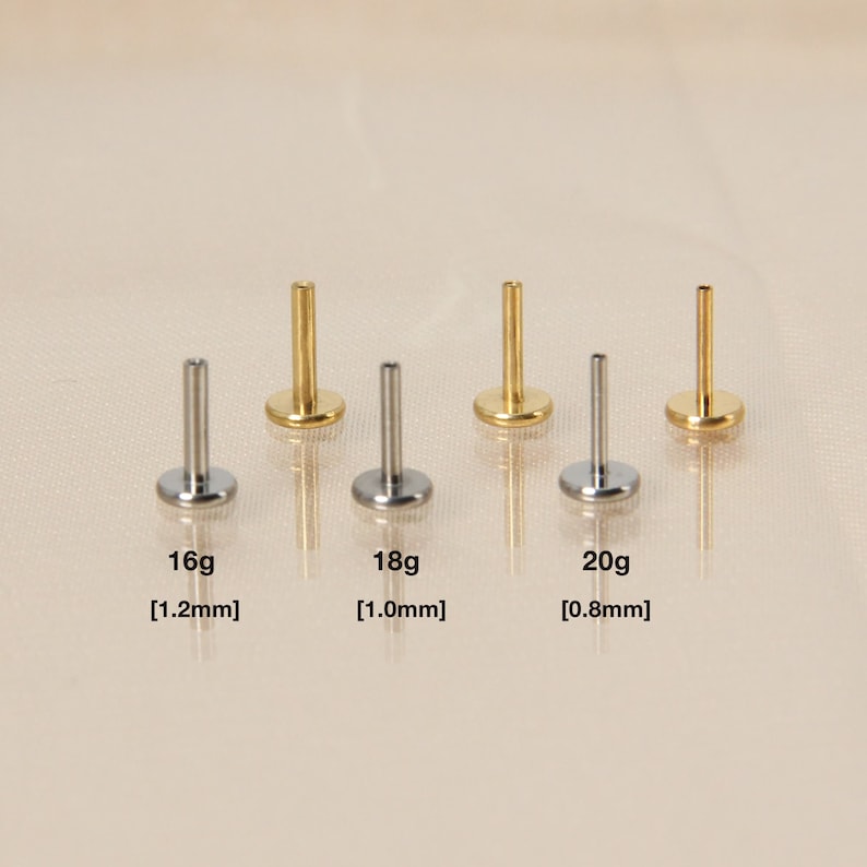 May include: Five surgical steel body jewelry studs in different sizes. The studs are 16g [1.2mm], 18g [1.0mm], and 20g [0.8mm].