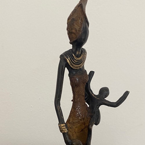 Authentic AfricanBrown bronze figurine with shops a child . Height 12ins /30cm