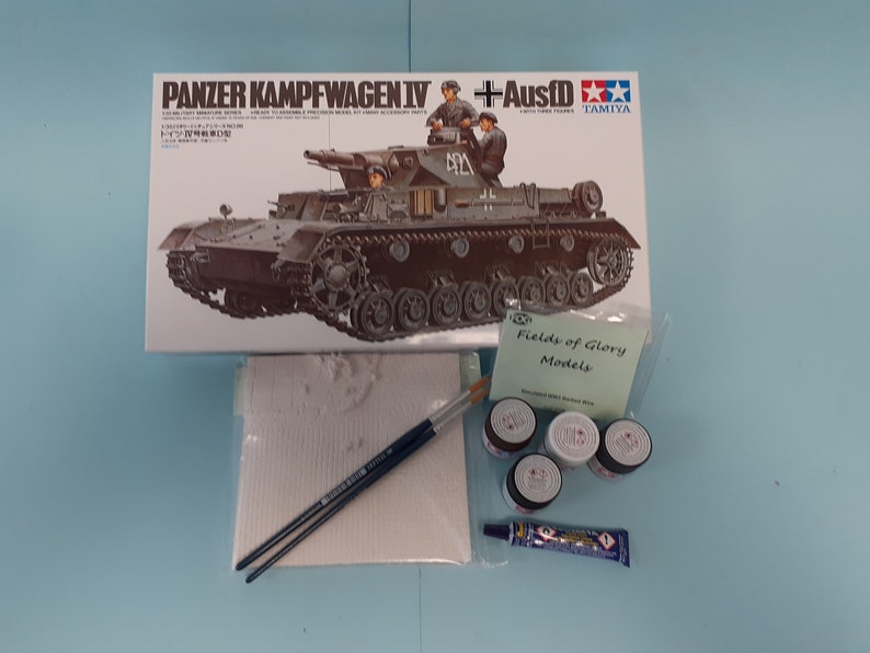 May include: A model kit box for a Panzerkampfwagen IV tank with Ausf.D, along with paint, glue, brushes, and sandpaper. The box is from Tamiya and features a detailed image of the tank.