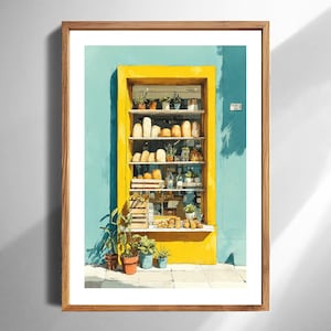 May include: Watercolour painting of a yellow bakery storefront against a blue wall. The window displays various baked goods, plants, and bottles. The artwork is framed in a wooden frame.