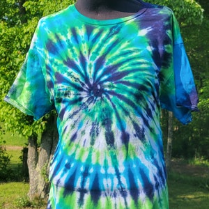May include: A tie-dye t-shirt with a blue, green, and black swirl pattern.