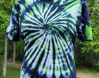 Può includere: Una maglietta tie-dye nera e verde con un design a spirale.