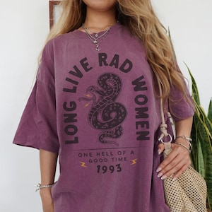 May include: Purple oversized t-shirt with a graphic of a snake and the text "Long Live Rad Women" and "One Hell of a Good Time 1993".