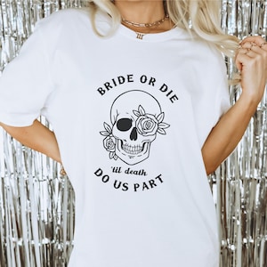May include: White t-shirt with a black skull and roses graphic. The text "Bride or Die 'til death do us part" is printed on the shirt.