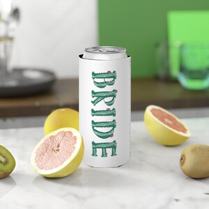 May include: White can cooler with a green cactus design that spells out the word "BRIDE".