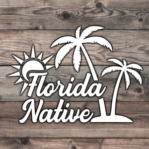 May include: White graphic design on a wood background with the text "Florida Native" and images of a sun, palm trees, and a stylized wave.
