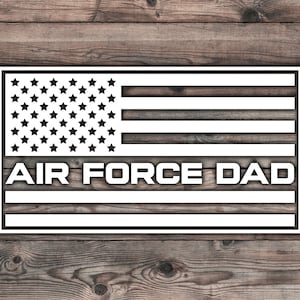 May include: White silhouette of an American flag with the words "AIR FORCE DAD" in the center. The flag is on a woodgrain background.