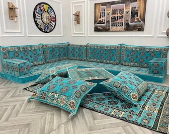 May include: A turquoise blue sectional sofa with patterned cushions and throw pillows. The sofa is set on a patterned rug with a matching color scheme.