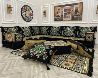 May include: A black and green patterned Moroccan floor seating set with cushions and a rug. The set includes a large L-shaped sofa, several square cushions, and a rectangular rug with intricate geometric designs.