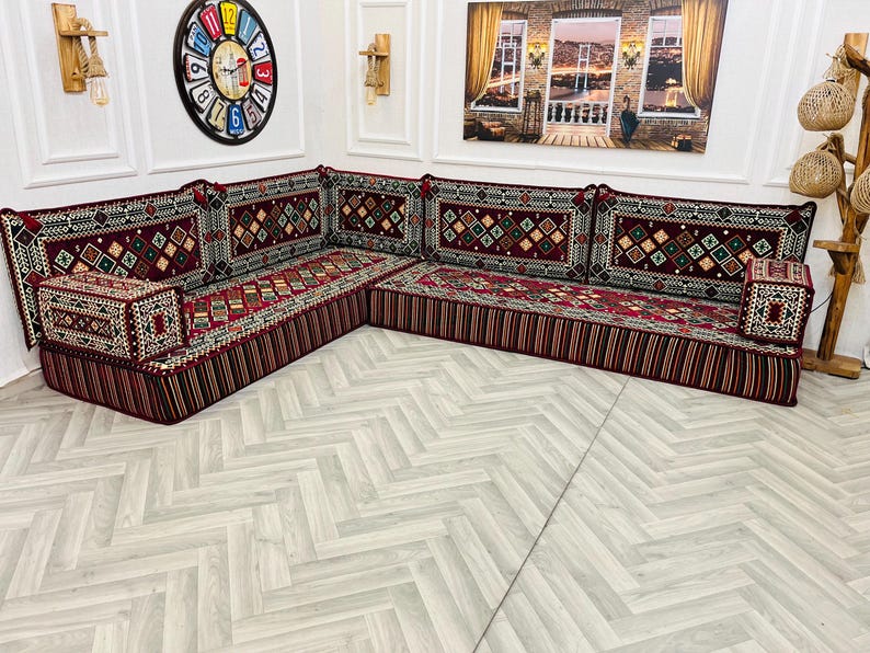 May include: A traditional red and gold patterned floor seating set with a corner design. The set features multiple cushions with intricate embroidery and a deep red base.
