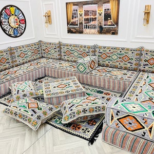 May include: A gray and white patterned sectional sofa with multiple cushions and throw pillows. The sofa is arranged in an L-shape and features a geometric design.