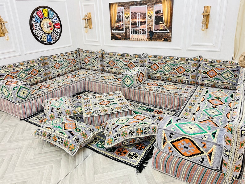 May include: A gray and white patterned sectional sofa with multiple cushions and throw pillows. The sofa is arranged in an L-shape and features a geometric design.