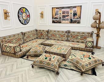 May include: A traditional Moroccan floor seating arrangement with patterned cushions and throw pillows. The seating is arranged in a U-shape with a small table in the center. The cushions are beige with brown, green, and orange geometric patterns. The throw pillows are beige with brown, green, and orange geometric patterns. The table is beige with a brown geometric pattern.