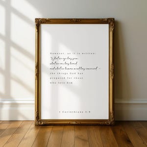 Op de afbeelding: Een ingelijste print met een gouden, sierlijke lijst. De print bevat een citaat uit 1 Korinthe 2:9 in zwart schrift op een witte achtergrond. Het citaat luidt: "Wat geen oog heeft gezien, wat geen oor heeft gehoord..."